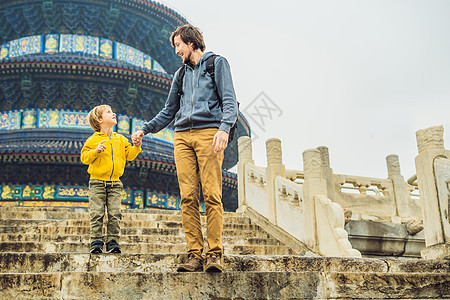 父子俩在北京天坛旅游 北京的主要景点之一 在中国与家人和孩子一起旅行的概念地标文化好奇心艺术建筑学天堂宝塔大厅手提箱假期图片