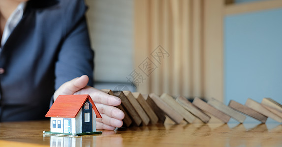 保护房子不倒在木块上 保险和风险概念 笑声安全预防房地产住房保险人抵押住宅机构财产商业图片