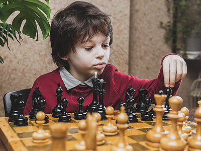 聪明的白种小孩在象棋游戏中动作图片