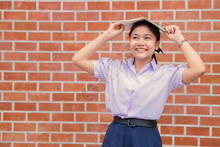 亚洲女青年学生制服快乐笑容 书本又回到学校概念中教育图片