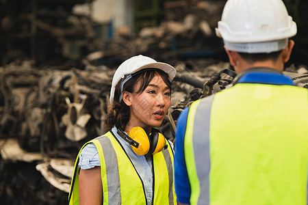 亚洲工程师工人职业女性与年轻男性一起在重工业工作场所工作 戴着头盔安全服图片