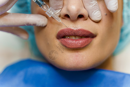 迷人女孩的丰唇注射 整形外科医生在诊所进行唇部注射 美容振兴面部护理程序皱纹美容师女士塑料皮肤治疗女性手术注射器图片