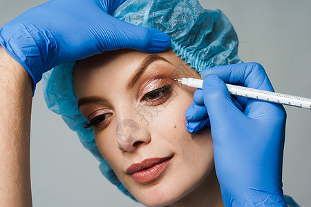 在整形外科手术前 在医疗诊所对面眼部区域进行整形改造时 将脸部上方的白光膜印记贴近病人乐器保健绘画医院女士卫生治疗眼皮手套图片