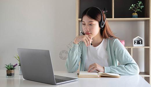 亚洲女学生在家里客厅的电脑上与老师进行视频会议电子学习 电子学习 在线 教育和互联网社交距离可防止 COVID19 病毒女士同事图片