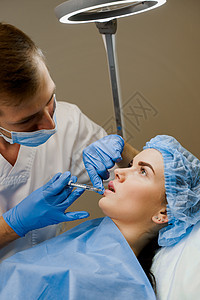 整形外科医生确实在诊所的嘴唇上注射过 化妆性美容面部治疗也进行过人工复健手术化妆品女性女孩病人皱纹手套注射器轮廓皮肤女士图片