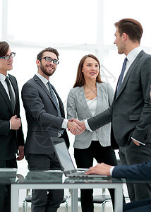 商业伙伴在签署合同后进行握手交流员工文书职业合伙电脑职场客户会议银行技术图片