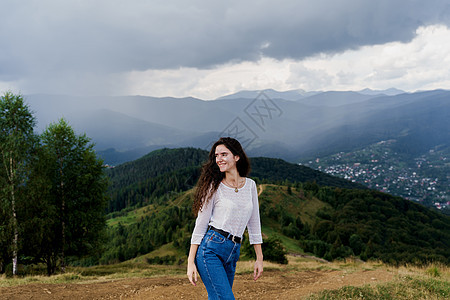 在乌克兰旅行的旅游 在雨前享受山丘风景的女孩 在Karpathian山区感到自由环境木头场景农村地形天空高山山脉草地全景图片