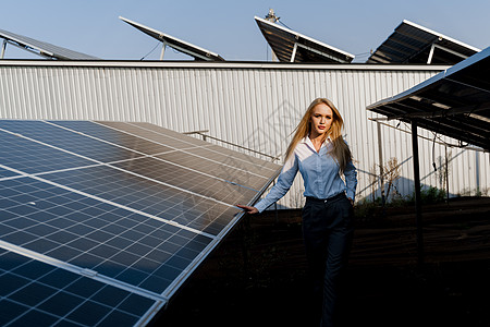 日落时 女孩在地面的2个太阳能电池板之间行走 家庭用电免费 地球的可持续性 绿色能源太阳能环境组件场地光电池车站活力太阳植物阳光图片