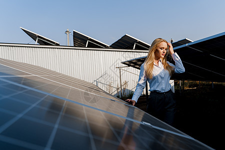 日落时 女孩在地面的2个太阳能电池板之间行走 家庭用电免费 地球的可持续性 绿色能源组件商业技术控制板太阳能电气生态植物电压蓝色图片