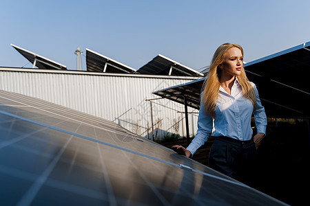 日落时 女孩在地面的2个太阳能电池板之间行走 家庭用电免费 地球的可持续性 绿色能源活力发电厂电气生态太阳能控制板光电池资源技术图片