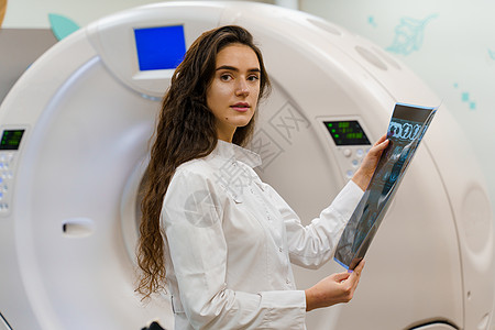 医疗诊所的CT诊断 持有病人脑部X光照片的女孩 经过计算机断层照相后患者 以及图片