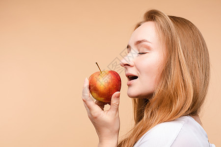 美丽的女孩 绑在后面的头发 吃着美味的苹果午餐快乐幸福微笑女士女性食物饮食小吃水果图片