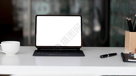 当代工作场所的侧面视图 木制桌子上有笔记本电脑 笔记本 咖啡杯和文具图片