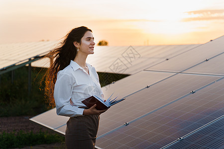 日落时 女孩和太阳能电池板在地面排成一行 太阳能电池发电厂业务车站工程服务资源控制板发电厂蓝色能源场地太阳图片
