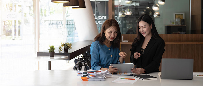 两个亚裔女商务人士一起工作 在办公室完成这份工作 来帮助她找到工作商务讨论工人微笑人士战略技术药片企业家会议图片