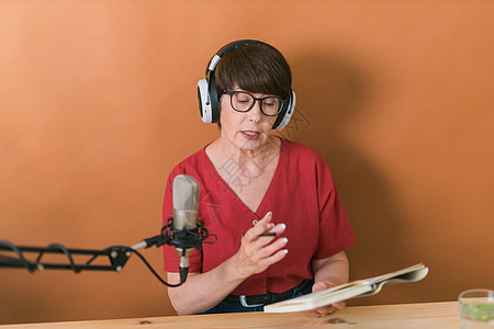 中年女电台主持人为在线节目制作播客录音  广播和 DJ 概念互联网播音员技术立体声工作室办公室商业播送工作女性图片