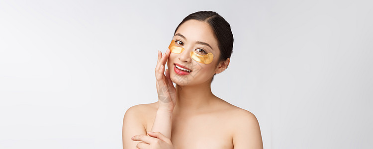 亚裔美容少女用金面罩遮住眼下的补丁来抚慰她的皮肤产品微笑凝胶眼睛护理女孩身体毛巾化妆品女性图片