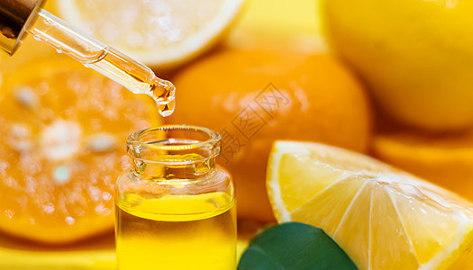黄色背景的橙色基本油 有选择的焦点呵护芳香香味植物身体水果柠檬奢华疗法香气图片