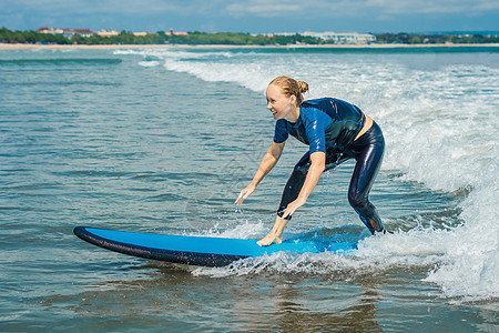 有蓝色冲浪的快乐的年轻女子初学者冲浪者在小海浪上玩得很开心 积极的家庭生活方式 人们户外水上运动课程和冲浪营暑假游泳活动冲浪板天图片