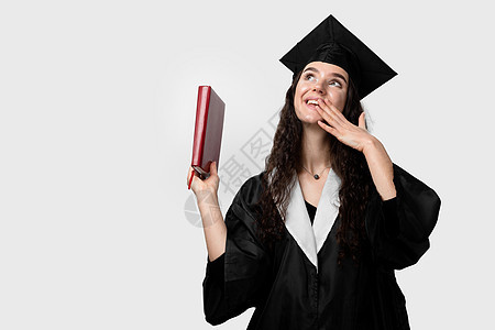 有书的学生在毕业长袍和帽子准备好完成大学 未来的科学领袖 身穿黑色长袍微笑的院士少妇商业职业野心学校女孩文凭工作成就学士学习图片