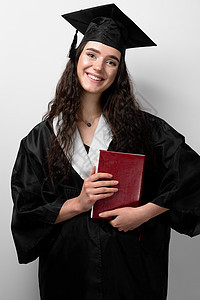 有书的学生在毕业长袍和帽子准备好完成大学 未来的科学领袖 身穿黑色长袍微笑的院士少妇成就者商业成功女性毕业典礼女孩女士学习领导者图片