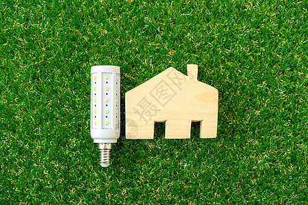木制房屋模型和绿色背景的灯泡环境生态创新回收力量技术解决方案活力电气创造力图片