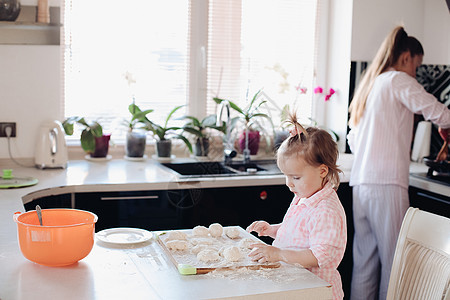 可爱的小孩在厨房帮父母拿钱馅饼家庭饼干食物女儿面团帮助孩子面粉成人图片