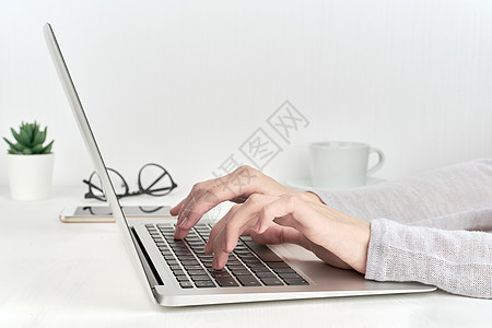 在笔记本电脑键盘 现代办公室工作或学习概念上打字的无法识别的人图片