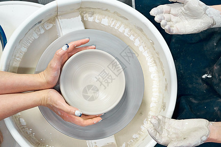 女性在轮子上做陶瓷陶器 手掌缝合式 自由职业妇女的概念创造力工作艺术家工匠学习工作室投掷黏土作坊制造业图片