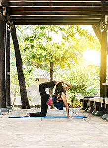 女孩做瑜伽和四头肌伸展健身 女人在户外做四头肌瑜伽 伸展瑜伽概念背景图片