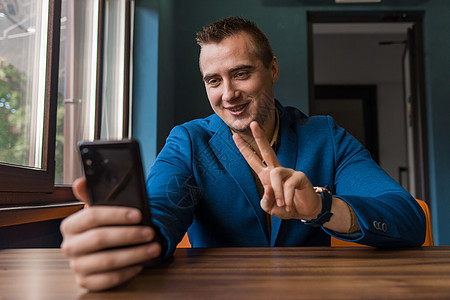 微笑 积极的商务人士时尚年轻人穿着夹克的白人肖像坐在咖啡馆的桌子旁 在视频链接上闲逛图片
