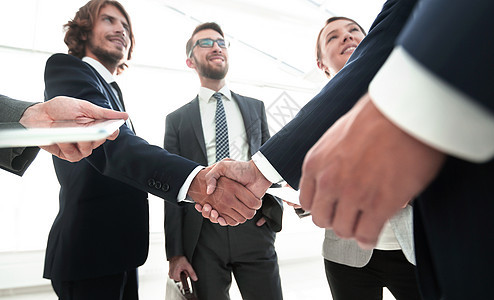 雇员们看看握手的商业伙伴们经理顾客协议团队生意会议女性职业工作管理人员图片