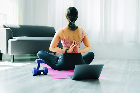 缓解压力 肌肉放松 呼吸练习 锻炼 冥想 亚洲年轻女性的肖像通过观看在线教程练习瑜伽来放松她在办公室工作中的身体电脑视频肩膀女士图片