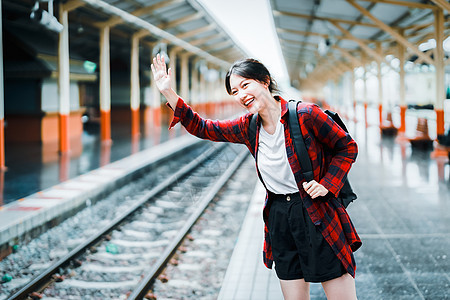 夏天 放松 度假 旅行 一个可爱的亚洲女孩的肖像 她微笑着向到达火车站等待旅行的朋友们挥手致意图片