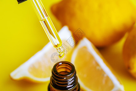 黄色背景的柠檬基本油 有选择性的焦点芳香按摩卫生呵护奢华化妆品温泉药品香气疗法图片
