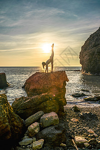 女体操运动员在海边的海日落前 在海滩上接受训练 有绳子 有相片系列海洋乐趣旅行天空海岸线太阳光线缠绕热带体操晴天图片