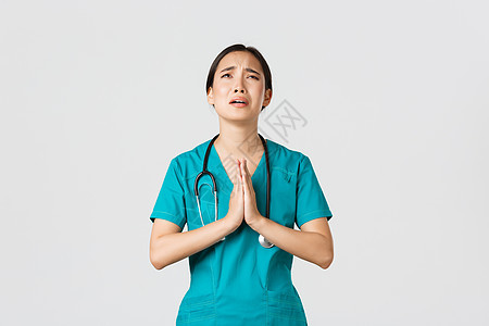 Covid19 保健工作者 大流行病概念 过度劳累的悲伤和疲倦的女医生 求救护士 祈祷上帝 为压力而哭泣 站立白种背景医师暴发病图片