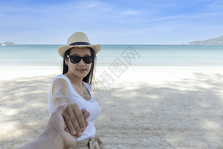 POV 观点跟着我戴墨镜的女人手牵着男朋友去海边 看着相机 走在海滩的愉快的女孩后面看法 夫妇在海滩上度假旅行 暑假太阳游客幸福图片