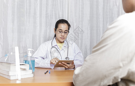 医生在她的诊所工作 倾听和分析病人 医生分析平板电脑 倾听解释他的症状 医疗保健和援助概念图片