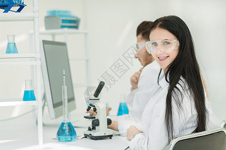 女科学家坐在一个实验室的桌子上图片