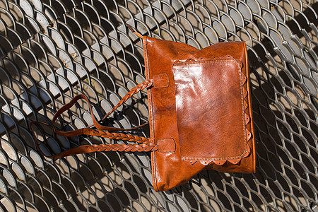 金属质料背景上橙色皮包的近身照片男人商业钱包旅行手提箱带子管理人员公文包配饰人士图片