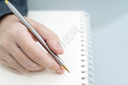 手在桌上写笔记本人士女性办公室写作学生杂志工作商业记事本日记图片