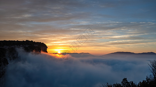 日出时 山上云层上空有蓝色的天空图片