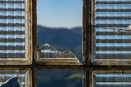 透过废弃建筑中破碎的窗户 看见山岳的景象村庄沉降风景玻璃乡村世界末日时间废墟装饰品爬坡图片