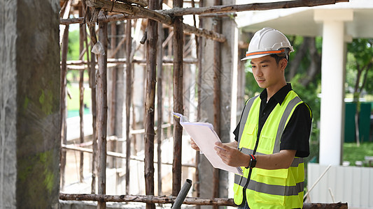 工程经理身着安全背心和头盔 站在建筑工地图片