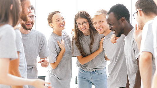 一群快乐的年轻人站在一个明亮的房间里团体团结男性女性教育合伙友谊学习大学课堂图片