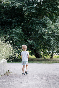 小男孩在公园迷路了 孩子独自一人在城市公园里图片