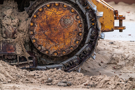 在芝加哥海滩上 一辆老式大型工业用黄色推土机机器的轨迹被风蚀 生锈和磨损 这是一张特写的照片金属曲目风化车辆设备运输齿轮图片