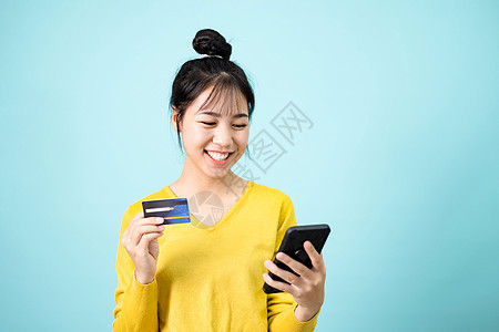 青年妇女使用智能手机和信用卡借方人士支付商务折扣女士快乐银行业幸福技术图片