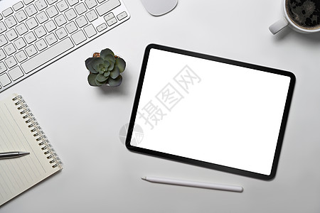 白色办公桌顶端视图数字平板 笔记本 咖啡杯和辅助设备图片